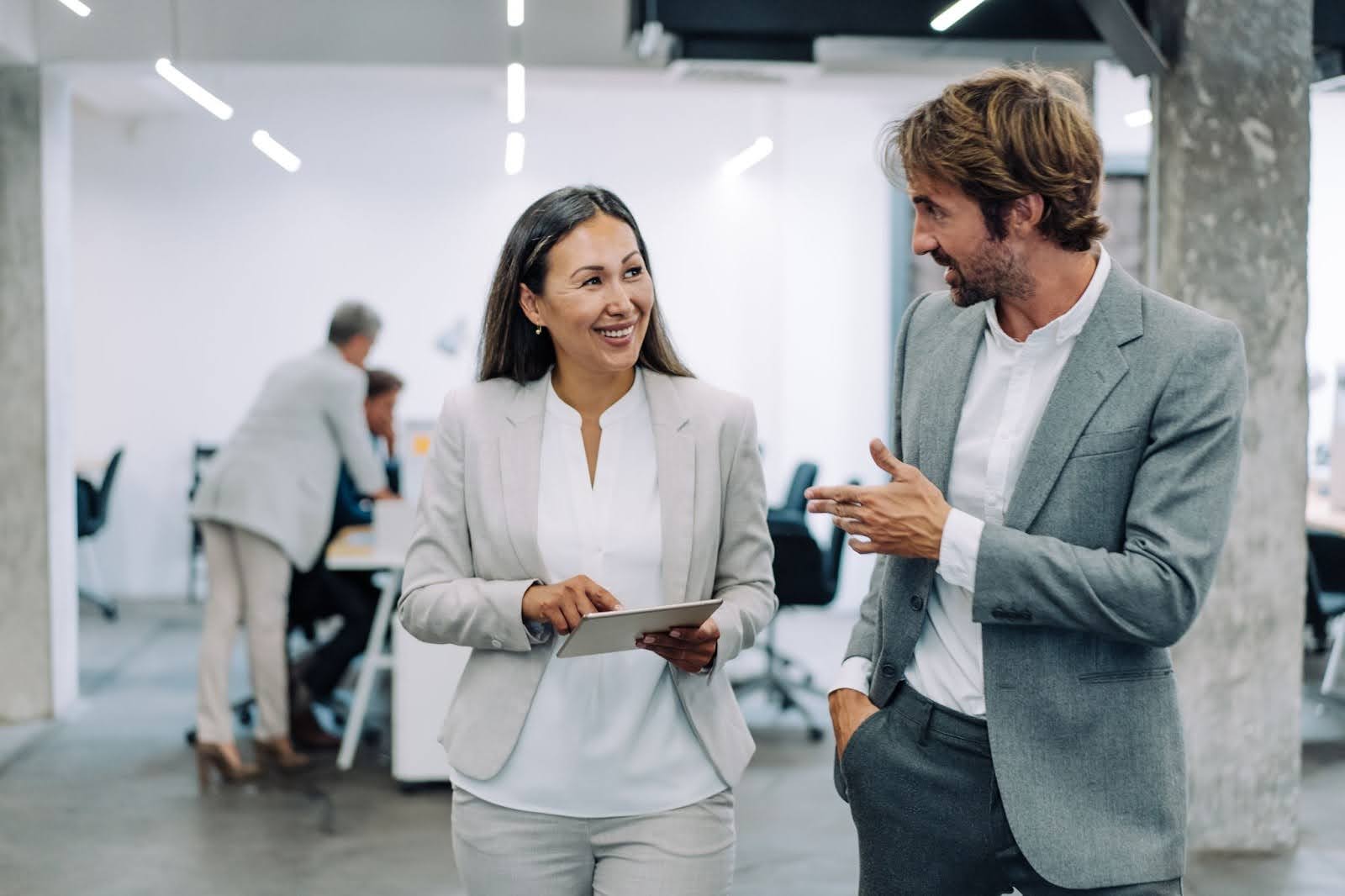 Woman holding a tablet talking to a man